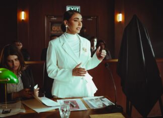 Jak wygląda dzień na sali sądowej podczas procesu mafii: kulisy zabezpieczeń, procedur i gry obrońców Pewna siebie prawniczka w białym garniturze przemawia w eleganckiej sali sądowej